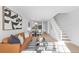 Open-concept living area with modern furnishings, including a sleek sofa, contemporary art, and a staircase to the upper level at 1818 S Quebec Way # 2-3, Denver, CO 80231