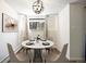 Bright dining area features modern chandelier, white walls, and a round dining table with seating for four at 2700 S Holly St # 100, Denver, CO 80222