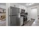 Modern kitchen featuring white cabinets, stainless steel appliances and view to living area at 2700 S Holly St # 100, Denver, CO 80222