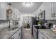 Modern kitchen featuring white cabinets, stainless steel appliances, and a view to breakfast nook at 2700 S Holly St # 100, Denver, CO 80222