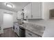 Modern kitchen with white cabinets, stainless steel appliances, countertops and sink at 2700 S Holly St # 100, Denver, CO 80222