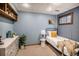 Spare bedroom in basement with comfortable twin bed and wood paneled accent wall at 8304 S Upham Way, Littleton, CO 80128
