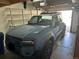 Attached garage with storage shelving features a modern blue Toyota parked inside at 8304 S Upham Way, Littleton, CO 80128