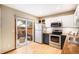 Well-lit kitchen with modern appliances and sliding glass doors to a patio at 8304 S Upham Way, Littleton, CO 80128