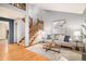 Bright living room with hardwood floors, a staircase, and comfortable seating at 8304 S Upham Way, Littleton, CO 80128