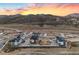 A panoramic view of a modern community, set against a backdrop of mountains and a colorful sunset sky at 14412 Pansy Loop, Morrison, CO 80465