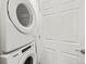 A close-up shot of a stacked Whirlpool washer and dryer unit next to a white door at 14412 Pansy Loop, Morrison, CO 80465