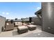 A luxurious rooftop patio featuring wicker furniture, including a sofa, chairs, ottomans, and a coffee table at 14412 Pansy Loop, Morrison, CO 80465
