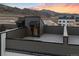 An empty rooftop patio with mountain views in the background, under a beautiful sunset at 14412 Pansy Loop, Morrison, CO 80465