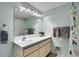 Bright bathroom with a large mirror, updated vanity, and shower-tub combo at 30382 Marys Dr, Conifer, CO 80433