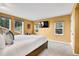 Bright bedroom with yellow walls, multiple windows with outdoor view and decorative details at 30382 Marys Dr, Conifer, CO 80433