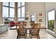 Bright dining area with large windows and seating, adjacent to a cozy living room with large sofas at 30382 Marys Dr, Conifer, CO 80433