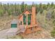 An eye-level exterior elevation view showcases a home featuring a wrap-around deck, perfect for enjoying the serene natural surroundings at 30382 Marys Dr, Conifer, CO 80433