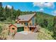Charming hillside home with a spacious deck and attached garage overlooking lush greenery at 30382 Marys Dr, Conifer, CO 80433