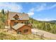 Two story home with wood siding and a detached garage; surrounded by trees at 30382 Marys Dr, Conifer, CO 80433
