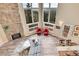 Bright living room with stone fireplace, hardwood floors, and a wall of windows with scenic views at 30382 Marys Dr, Conifer, CO 80433