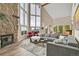Bright living room featuring a stone fireplace, large windows, and vaulted ceilings at 30382 Marys Dr, Conifer, CO 80433