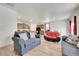 Open-concept living room featuring hardwood floors, neutral walls, and modern sofas leading to kitchen at 45831 Silverdrop Ave, Bennett, CO 80102