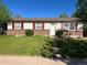 Charming single-story home featuring red shutters, and a well-lit front yard with a stone pathway to the door at 5543 Victor St, Denver, CO 80239