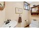 Charming powder room with decorative windows, pedestal sink, and stained wood trim at 2595 S Adams St, Denver, CO 80210