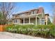 Charming two-story home featuring a welcoming front porch and landscaped front yard with mature hedges at 2595 S Adams St, Denver, CO 80210