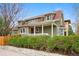 Charming two-story home featuring a covered front porch, shingle siding, and well-manicured landscaping at 2595 S Adams St, Denver, CO 80210