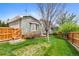 Charming home featuring a well-manicured lawn, mature trees, and a wooden fence at 2595 S Adams St, Denver, CO 80210