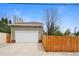 Two car garage featuring a concrete driveway and a wooden fence at 2595 S Adams St, Denver, CO 80210