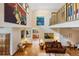 Two-story living room with hardwood floors, a leather sofa, and an abundance of artwork at 2595 S Adams St, Denver, CO 80210