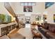 Open living room with hardwood floors, staircase, large windows, and comfortable seating at 2595 S Adams St, Denver, CO 80210
