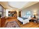 Comfortable main bedroom with hardwood floors, decorative windows, tray ceilings, and custom cabinets at 2595 S Adams St, Denver, CO 80210