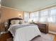 Bedroom with a large bed, a dresser, many windows with sheer curtains, and tan walls at 1444 Fairfax St, Denver, CO 80220