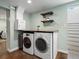 Functional laundry room with a washer, dryer, storage shelves and hooks at 1444 Fairfax St, Denver, CO 80220