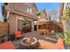 Cozy backyard with a fire pit, brick patio, orange lounge furniture, and outdoor entertaining space at 2222 N Washington St, Denver, CO 80205