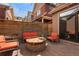 Private backyard featuring a brick patio, modern orange furniture, wooden privacy fence and lush potted plants at 2222 N Washington St, Denver, CO 80205