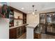 Stylish bar area with wood cabinets, wine cooler, brick backsplash, and pendant lighting at 2222 N Washington St, Denver, CO 80205