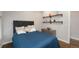 Cozy bedroom featuring hardwood floors, a comfortable queen-sized bed, and wall shelves at 2222 N Washington St, Denver, CO 80205