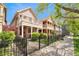 Street view of homes featuring welcoming front porches and landscaped lawns secured by black fences at 2222 N Washington St, Denver, CO 80205