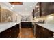 Open kitchen design with a marble counter, dark cabinets, and wooden flooring leading to the dining area at 2222 N Washington St, Denver, CO 80205