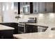 Modern kitchen featuring stainless steel appliances, black cabinetry, and a beautiful white tile backsplash at 2222 N Washington St, Denver, CO 80205