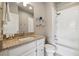 Clean bathroom featuring granite countertops, tub with shower, and bright white fixtures at 538 S Upham St, Lakewood, CO 80226