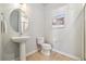 This bright bathroom features a pedestal sink, round mirror, and a separate shower with clear glass door at 538 S Upham St, Lakewood, CO 80226