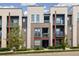 Modern townhome featuring balconies, stucco, gray brick and landscaped front yard at 538 S Upham St, Lakewood, CO 80226