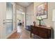 A nicely decorated home foyer has wood floors, a hall tree with mirror, and an open view to the office at 538 S Upham St, Lakewood, CO 80226