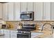 Modern kitchen with stainless steel appliances and mosaic backsplash at 538 S Upham St, Lakewood, CO 80226