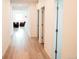 Bright hallway featuring wood floors and doors leading to various rooms of the home at 121 S Vandriver Way, Aurora, CO 80018