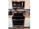 Close-up of stainless steel kitchen appliances, including a gas range and microwave at 121 S Vandriver Way, Aurora, CO 80018