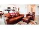 Cozy living room area featuring a leather sofa, chair, ottoman and nearby kitchen at 121 S Vandriver Way, Aurora, CO 80018
