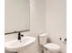 Modern bathroom featuring a pedestal sink, matte black faucet, and a water-efficient toilet at 6791 Navajo Ct, Denver, CO 80221