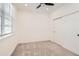 A minimalist bedroom features neutral tones, plush carpeting, and a window with blinds at 6791 Navajo Ct, Denver, CO 80221